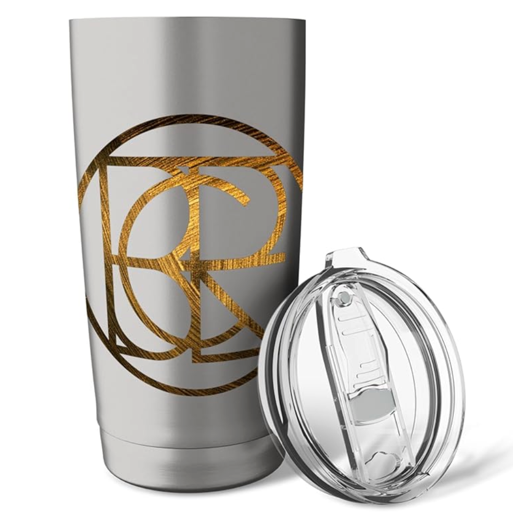 A stainless steel travel tumbler with a clear lid, featuring a gold textured monogram design on the side, shown against a plain white background.