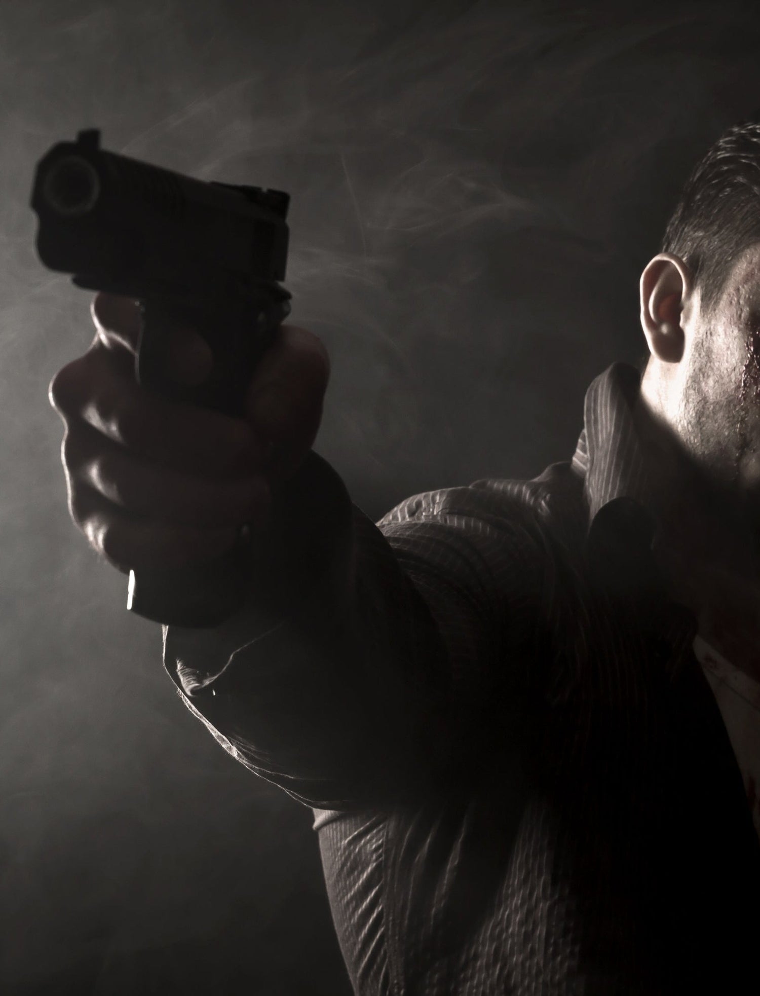 Max Bucther from Our Thing - Man holding a gun in a dark setting with smoke